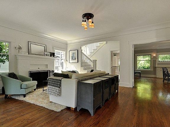 Large living area with wood burning fireplace, Oak hardwoods and period details.
