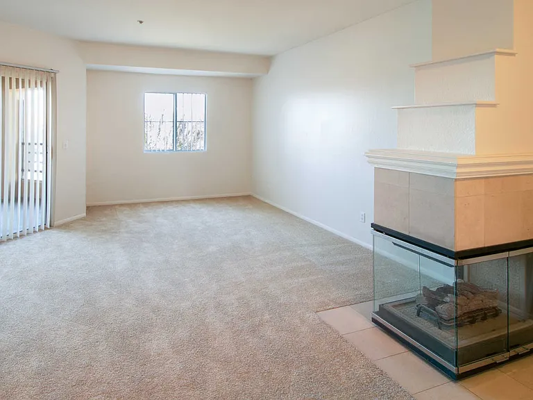 Carpeted Living Room with Gas Fireplace and Balcony