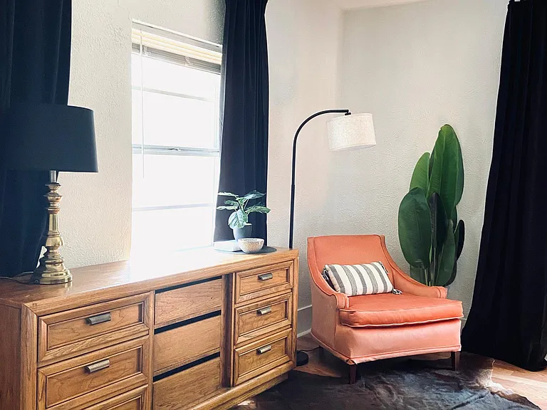 Comfortable Reading Corner and Full Dresser in the primary bedroom