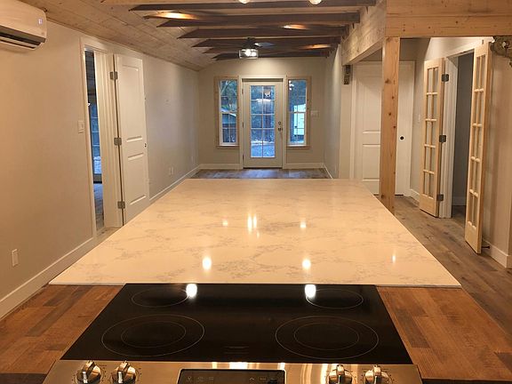 View to Entrance from Kitchen. Primary bedroom on left. Bedrooms 2 & 3 on right.