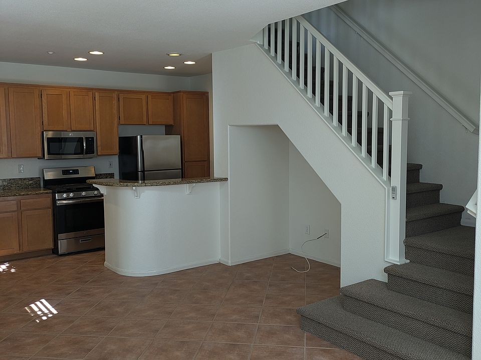 Main floor has direct access to the garage, a front patio, and nicely appointed kitchen with gas range, microwave, dishwasher, built-in desk, and stone slab bar & countertops.