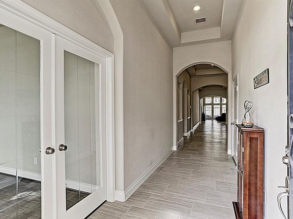 Enter the beautiful etched glass/wood door to the tiled foyer with high ceilings and recessed lighting.