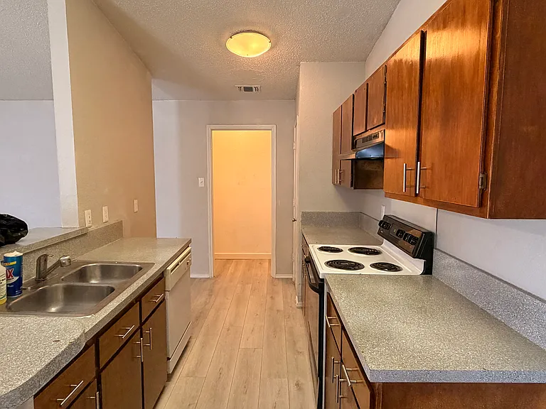 Kitchen with Stove, Sink, Pantry + Laundry Room at end of Hall