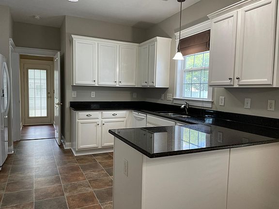 Granite counters, white cabinetry and appliances.