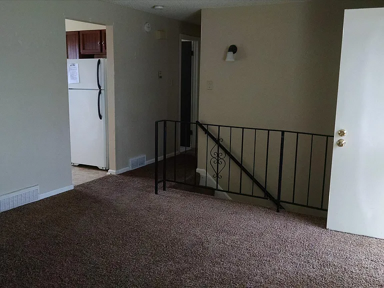 Living room with view of hallway, stairs to basement, and kitchen doorway.