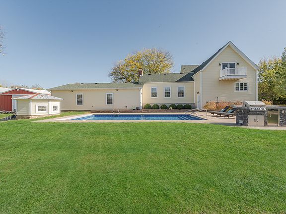 Extensive brick paver patio surrounds the pool and has a built-in grill, and bar refrigerator that w