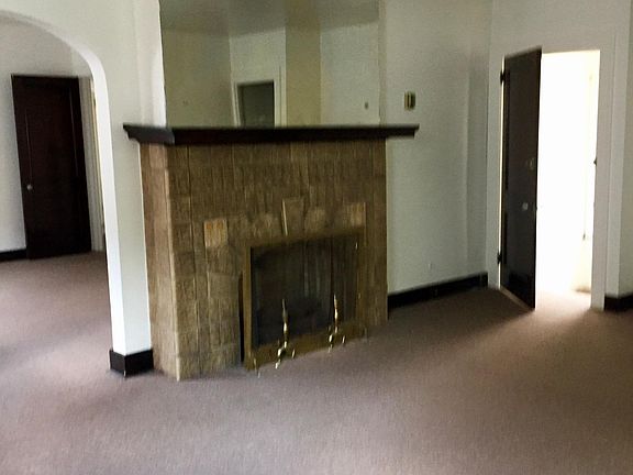 Living room with decorative fireplace and door to staircase