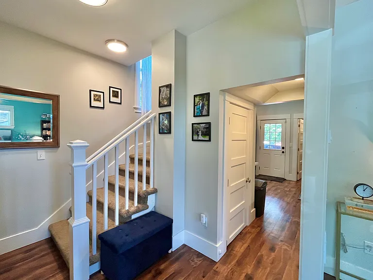 Coat area, passthrough to kitchen, staircase leading upstars