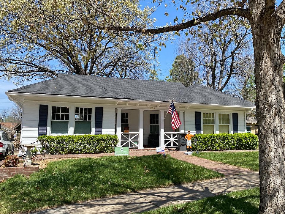 Front with covered porch. There are 2 chairs and side table under the porch.