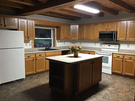 Kitchen area with wooden ceiling and log beams
