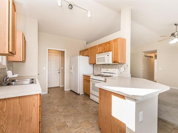 Kitchen w/ backslash and ample amounts of counter space w/ breakfast bar