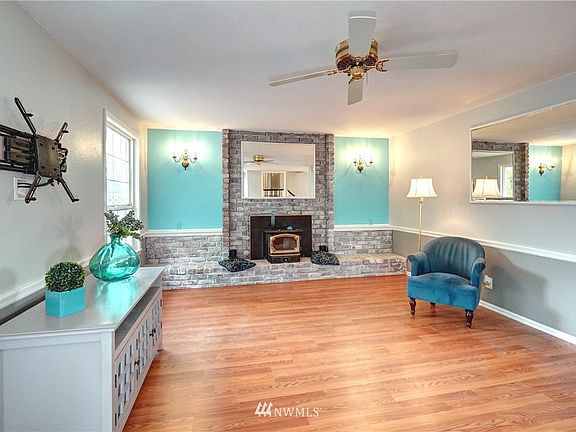 The lovely living room has continued easy care flooring, white mill work and a warm fireplace with brick hearth. 