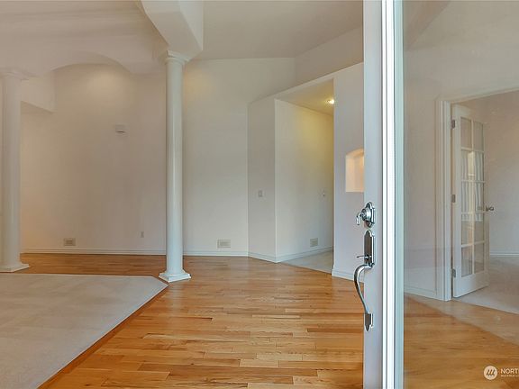 The entry opens to gleaming hardwood flooring throughout.>