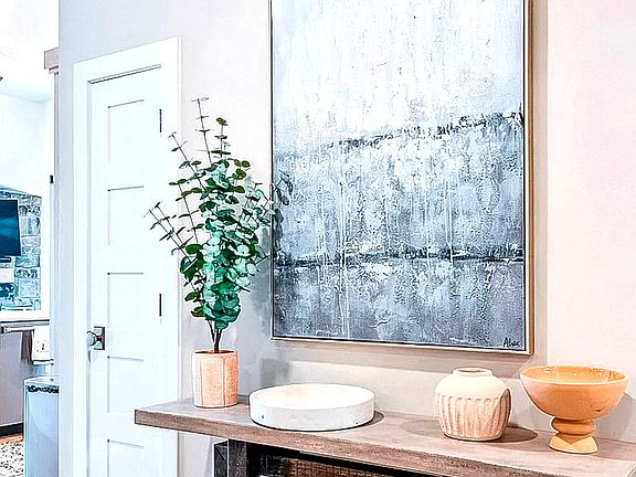 Welcoming entryway with large-scale abstract art and fresh eucalyptus plant _ a stylish first impression