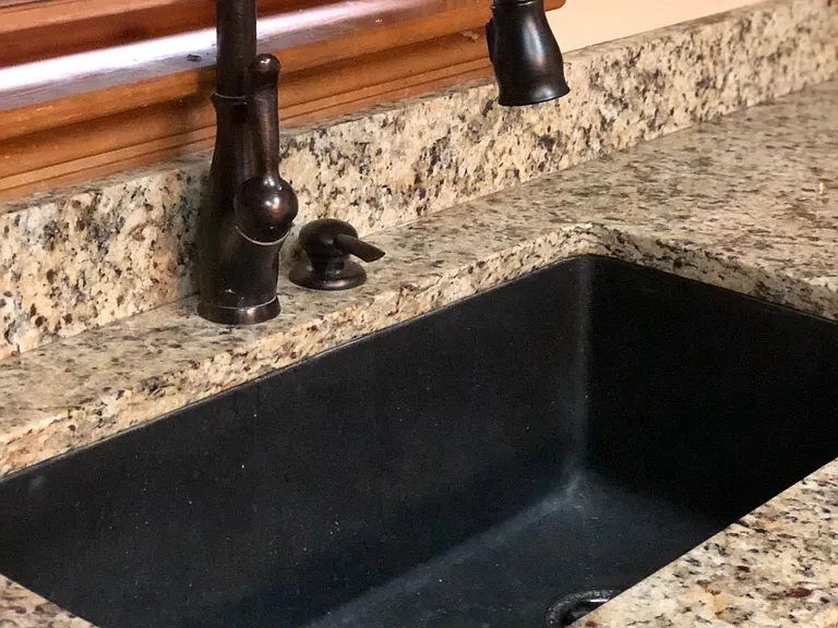 Granite countertops & HUGHE black granite sink with drain on right side. Makes it very easy to wash dishes. Trash Compactor