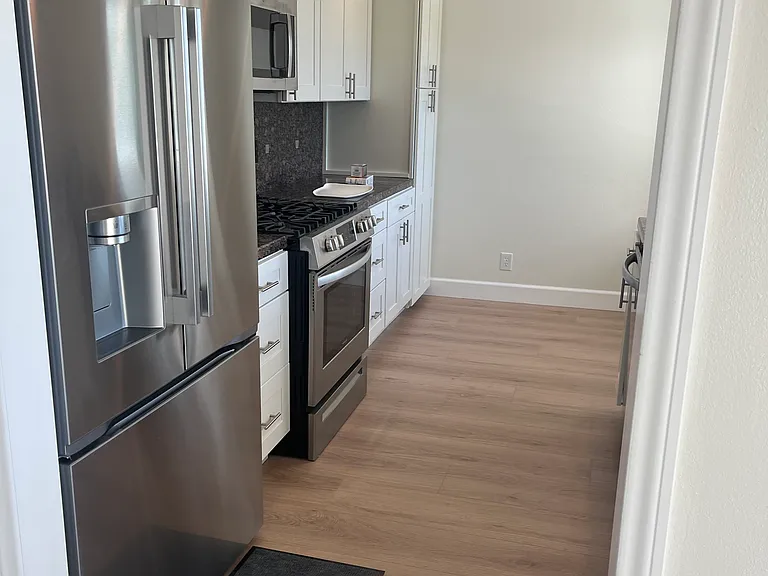 New kitchen cabinets and stainless steel appliances including a gas range/oven.