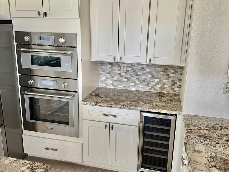 Kitchen equipped with Thermador oven and microwave, along with a built-in wine refrigerator