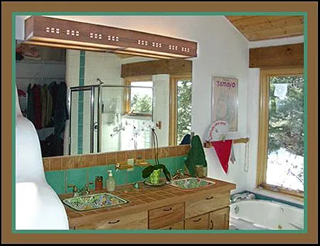 The Main bathroom with twin hand-painted Mexican sinks and a Jacuzzi bath for two. Double wide mirror with indirect dimmable cedar wood lighting overhead.