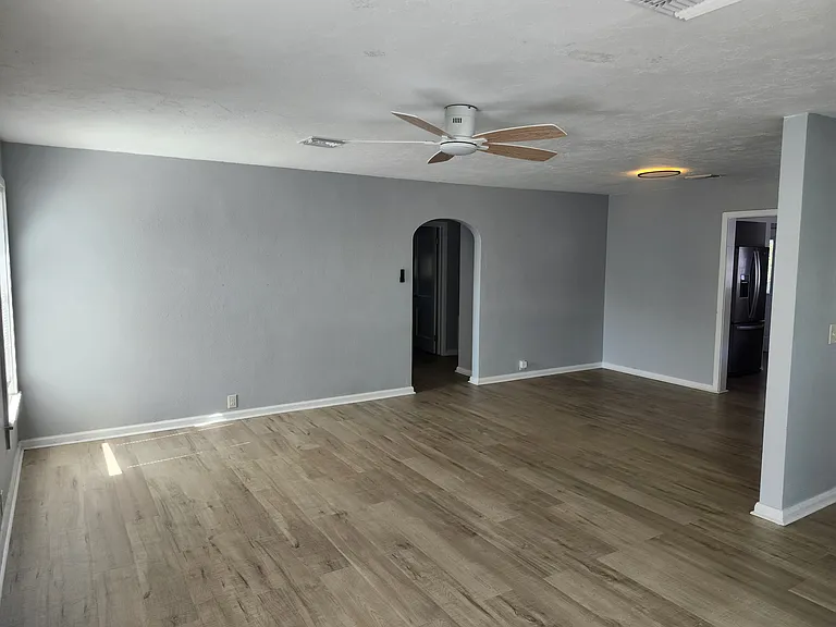 Living room and dining room arch entry into hallway for bathroom and bedrooms.