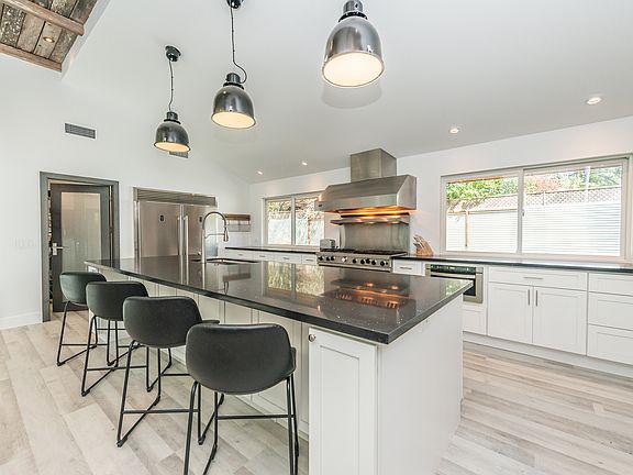 Vaulted great room with exposed beams and chef's kitchen