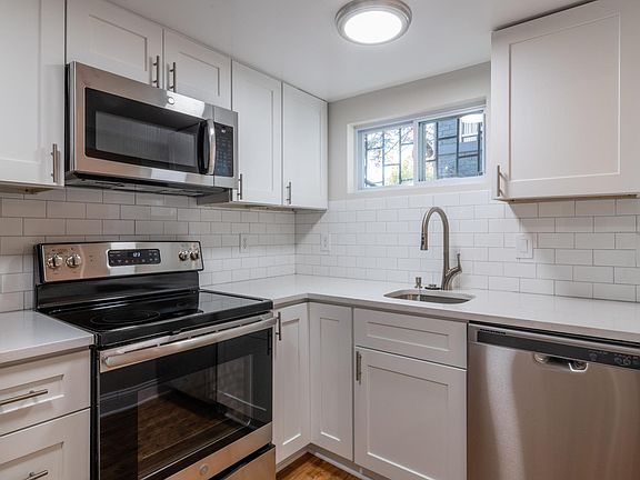 Kitchen with brand new stainless steel appliances including an oven, microwave, fridge, and dishwasher