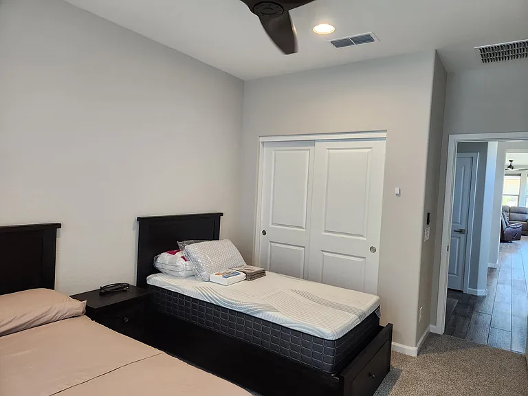 Guest bedroom with full and twin bed and ceiling fan