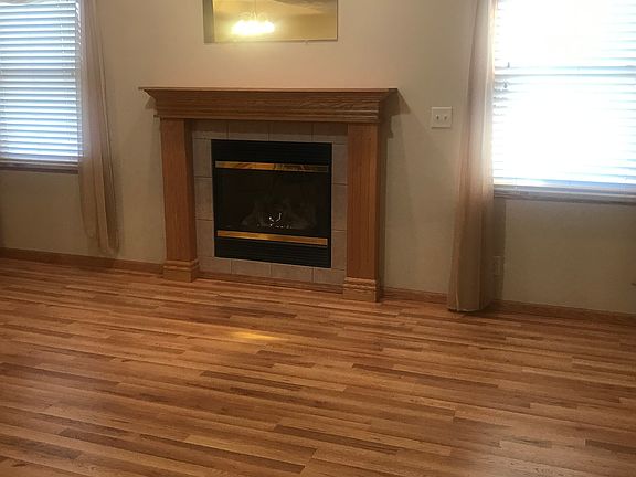 The living room's gas fireplace is flanked by two large windows; a third window is on another wall to the left of the fireplace.
The living room has a vaulted ceiling with a ceiling fan/lights.