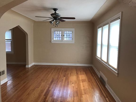 Large living room with lots of natural lighting and more stain glass windows. Inlaid hardwood floors just refinished