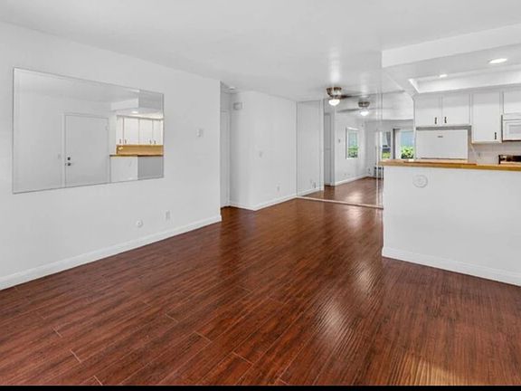 Wide view of den, dining area, kitchen and entrance to bedroom