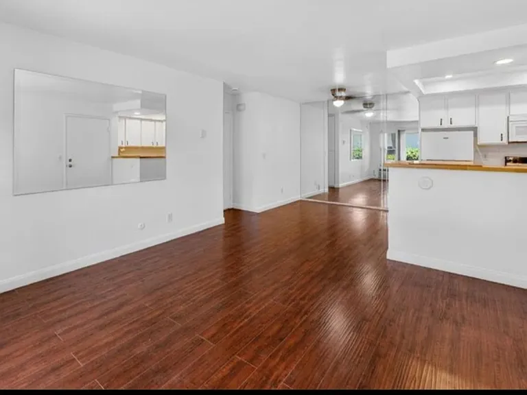 Wide view of den, dining area, kitchen and entrance to bedroom