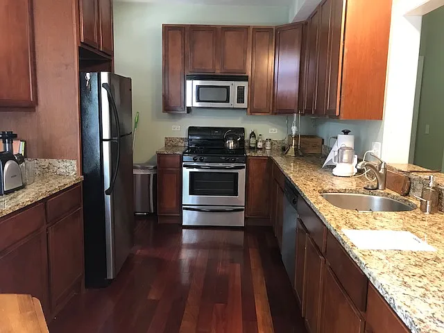 Kitchen with stainless steel appliances (dishwasher, fridge/freezer, stove, microwave) granite countertops and brazilian cherry floors