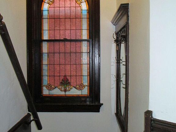 Entry way with original wood coat closet/mirror to right