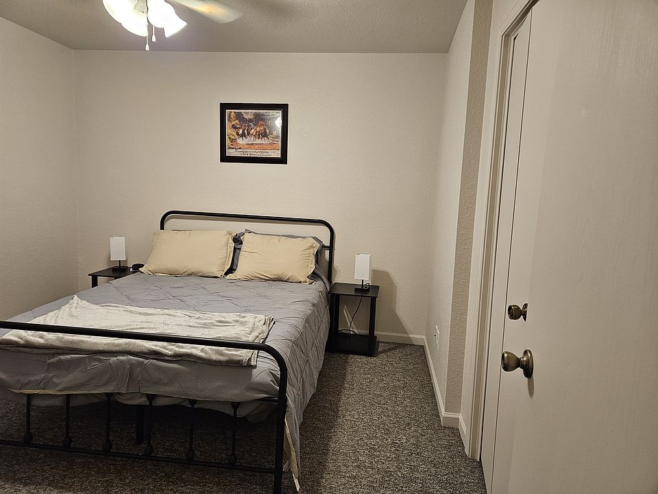 Main bedroom includes large closet, bed, nightstands, lamps, alarm clock and small dresser.