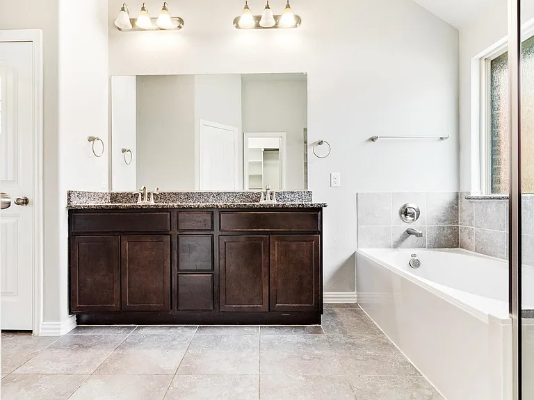 Dual vanity with dark wood cabinetry and stone-finish countertop
