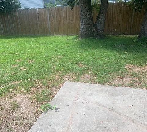 Large fenced in backyard with patio area