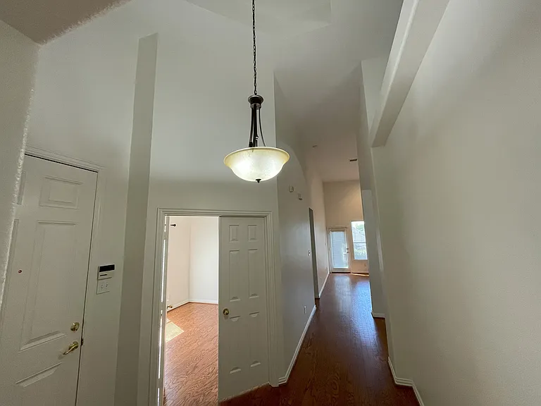 entry area looking towards the living room right, and bedroom/office through double doors left