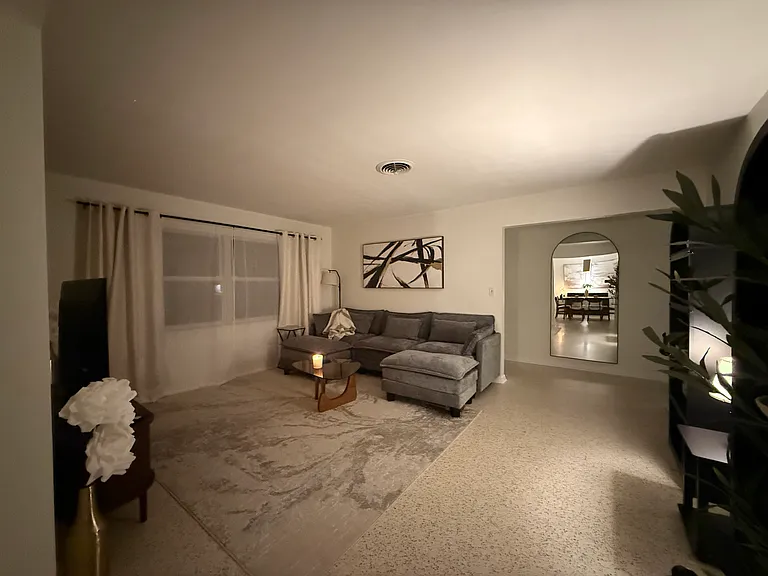 Main living room with tv, tv table, coffee table, large sofa, and duel bookcases.