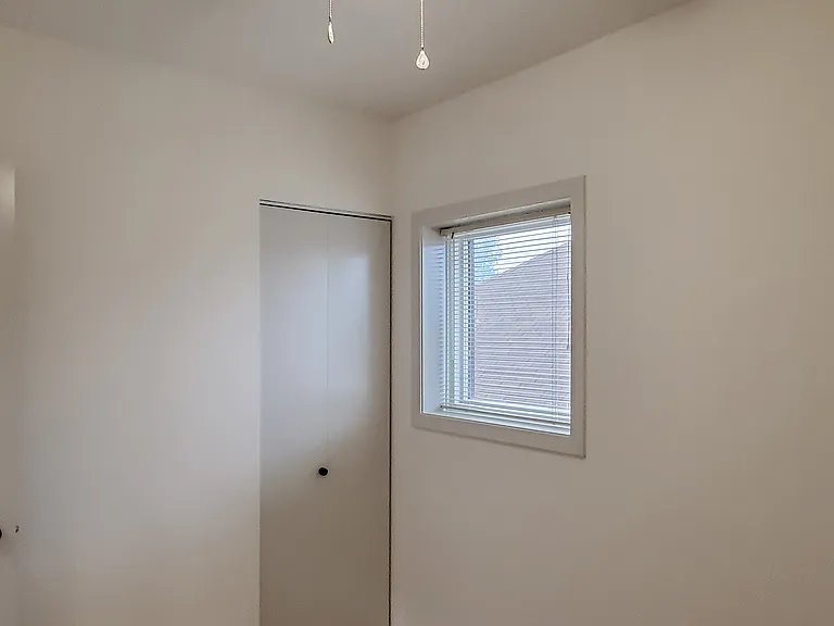 One small window and closet in the smaller bedroom.