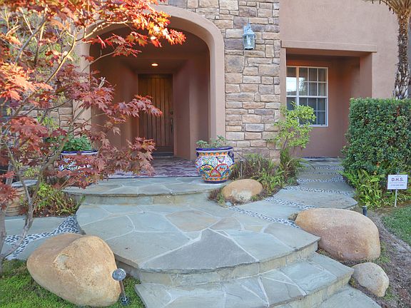 Entrance, patio, and professional landscaping