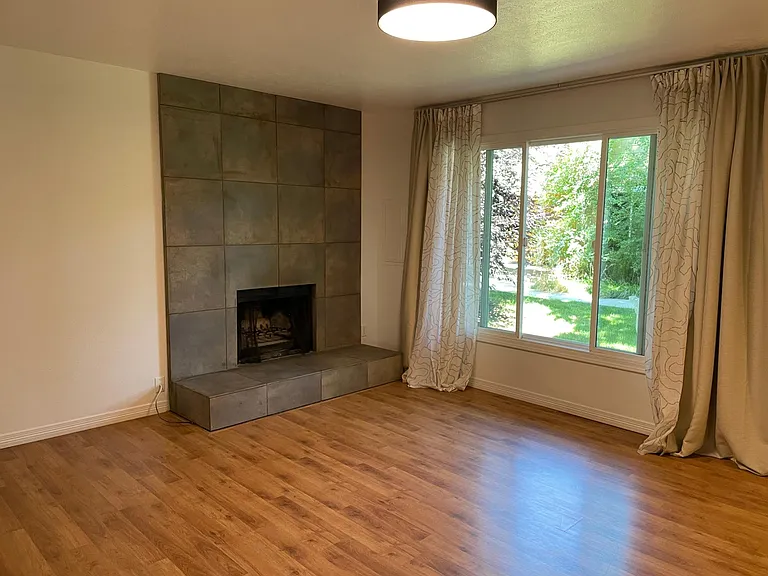 Living room with large picture window and fireplace.