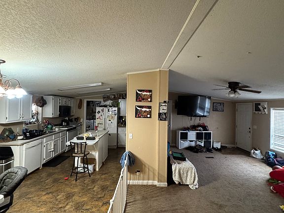 Standing in hallaway facing kitchen and living room split by divider wall.