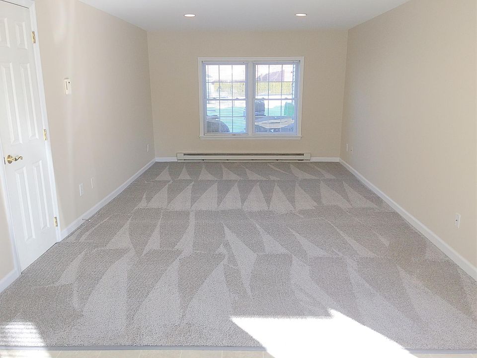 Living room with brand new carpet, coat closet on left side