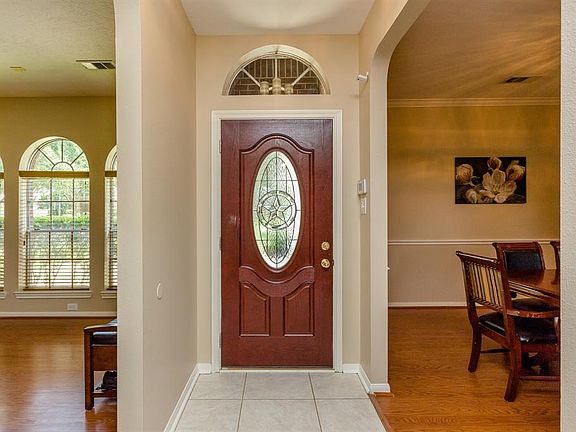 A pretty front door with leaded glass and arched transom window opens to this light and bright entry. In this photo the spacious living room is to the left and the formal dining room is on the right. This home's entire interior has been recently pain