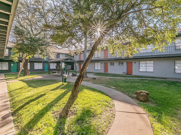 Enjoy the inviting exterior and well-maintained green spaces at Chapel Creek Apartments in Dallas.