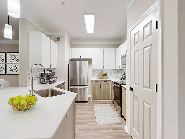 Bright kitchen with two toned cabinets with breakfast bar and view of dining room