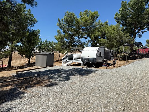 Spacious Exclusive parking area surrounded by tall trees providing lots of shade. Drive right up to your doorstep! Storage shed (approx 4' x 8') at left includes large zipper-tight clothes storage bag rack.