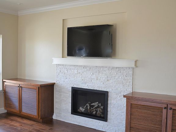 Ample storage, Large TV included over new Mendota gas fireplace
