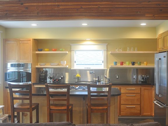 Kitchen with modern appliances, granite countertops and island seating.
