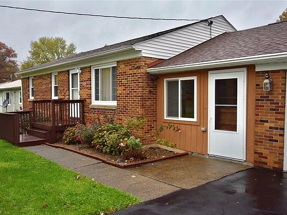 A close up view of the all brick, ranch home with a breezeway and 2 car garage.