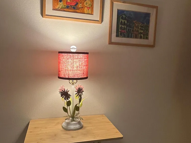 Master bedroom side table with lamp and original art